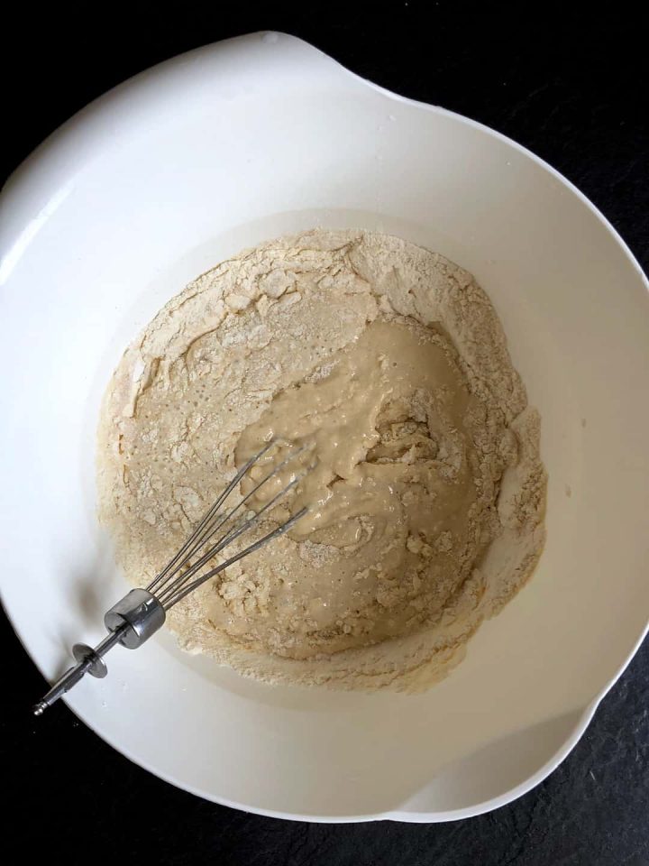 Combining ingredients for a yeast cake with a whisk.