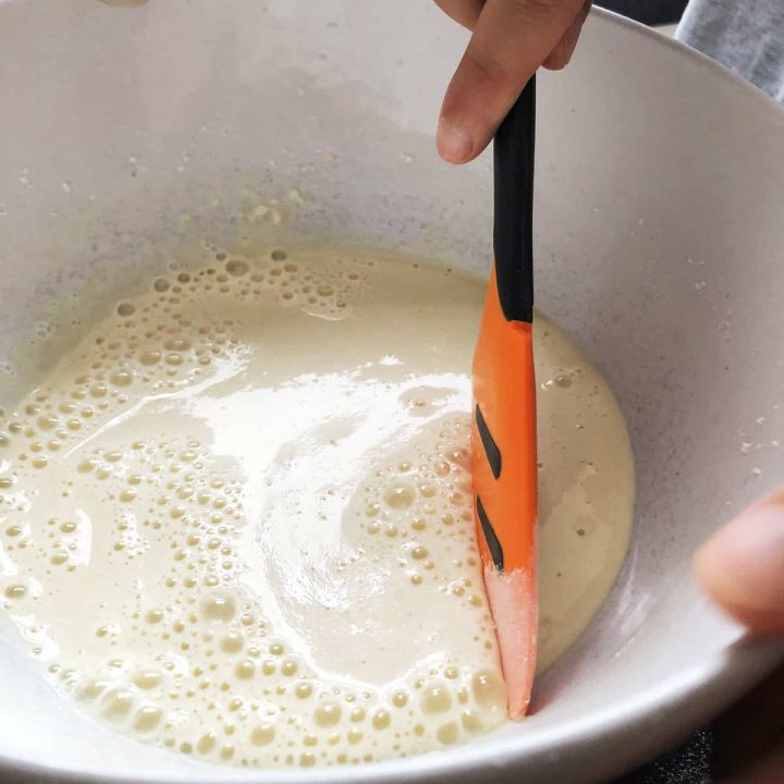 scraping sides of the bowl with a spatula