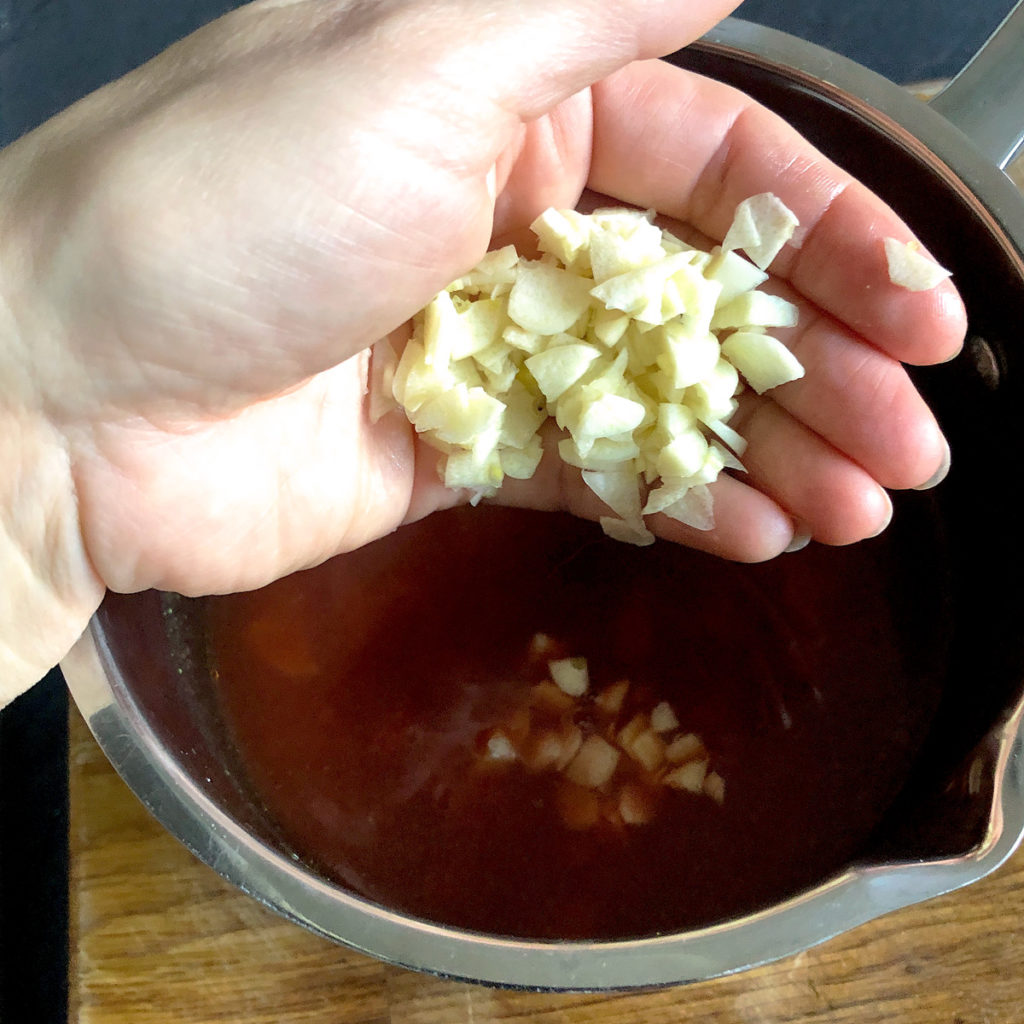 Adding chopped garlic to a stock.